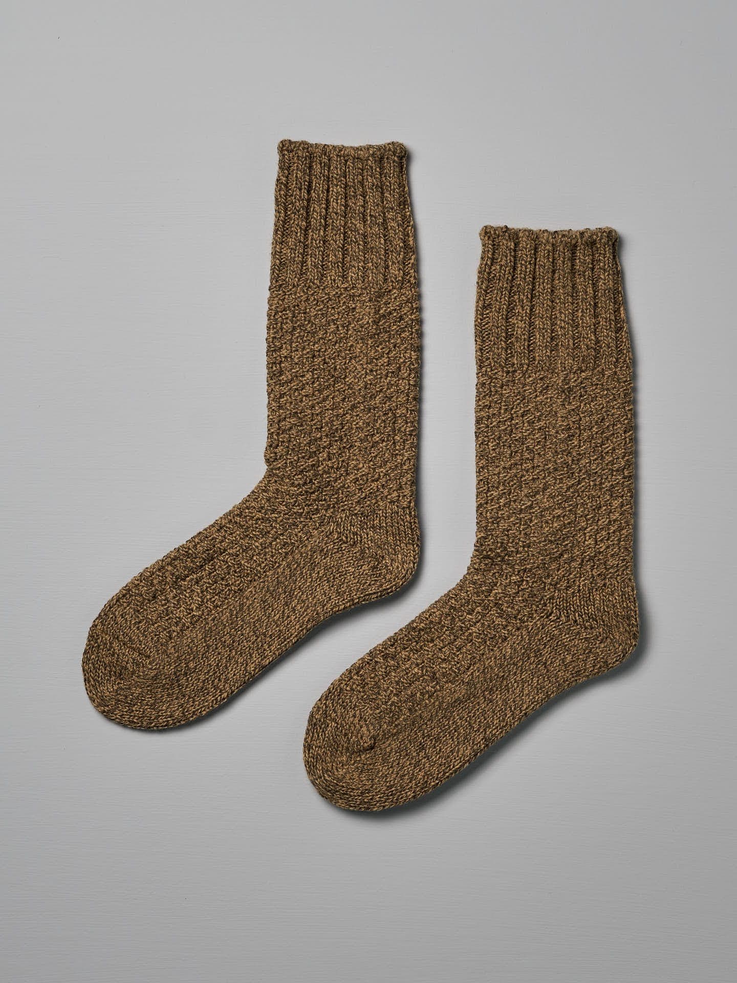 A pair of Wool Cotton Boot Socks – Mustard by Nishiguchi Kutsushita, suitable for both EUR shoe size and US men's shoe size, are laid flat on a light gray surface.