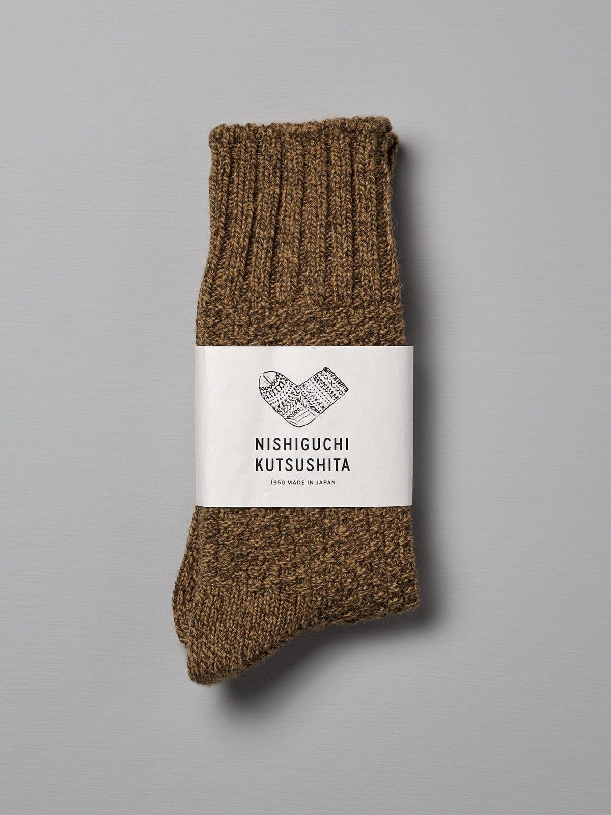 A pair of folded brown wool socks with a white label reading &quot;Nishiguchi Kutsushita, Made in Japan,&quot; designed to fit EUR shoe sizes perfectly.
