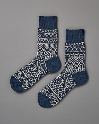 A pair of Oslo Wool Jacquard Socks in Seagull Blue, featuring a blue and white geometric knit pattern, is laid flat on a plain grey background. Includes women’s shoe size for easy selection.