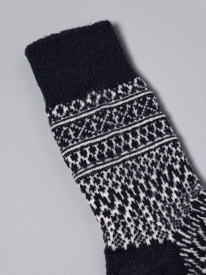 A pair of Nishiguchi Kutsushita Oslo Wool Jacquard Socks – Navy with a jacquard design pattern on them.