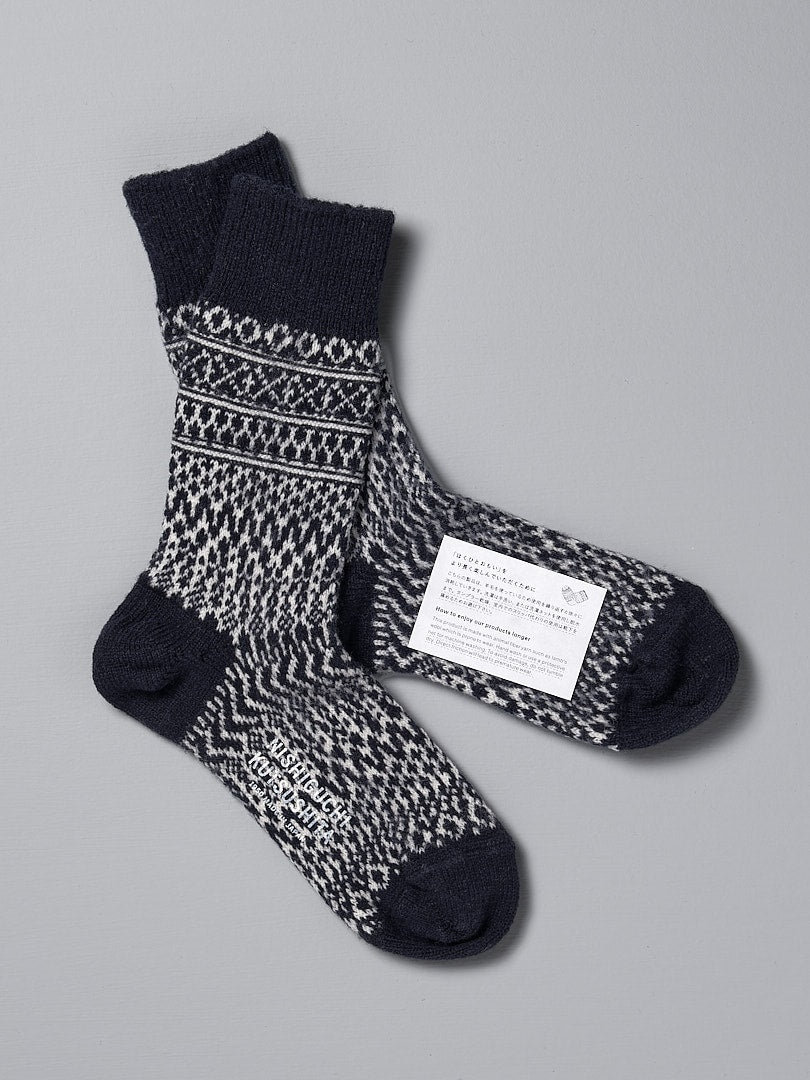 A pair of Oslo Wool Jacquard Socks – Navy by Nishiguchi Kutsushita, with a label on them, boasting an incredible warmth.