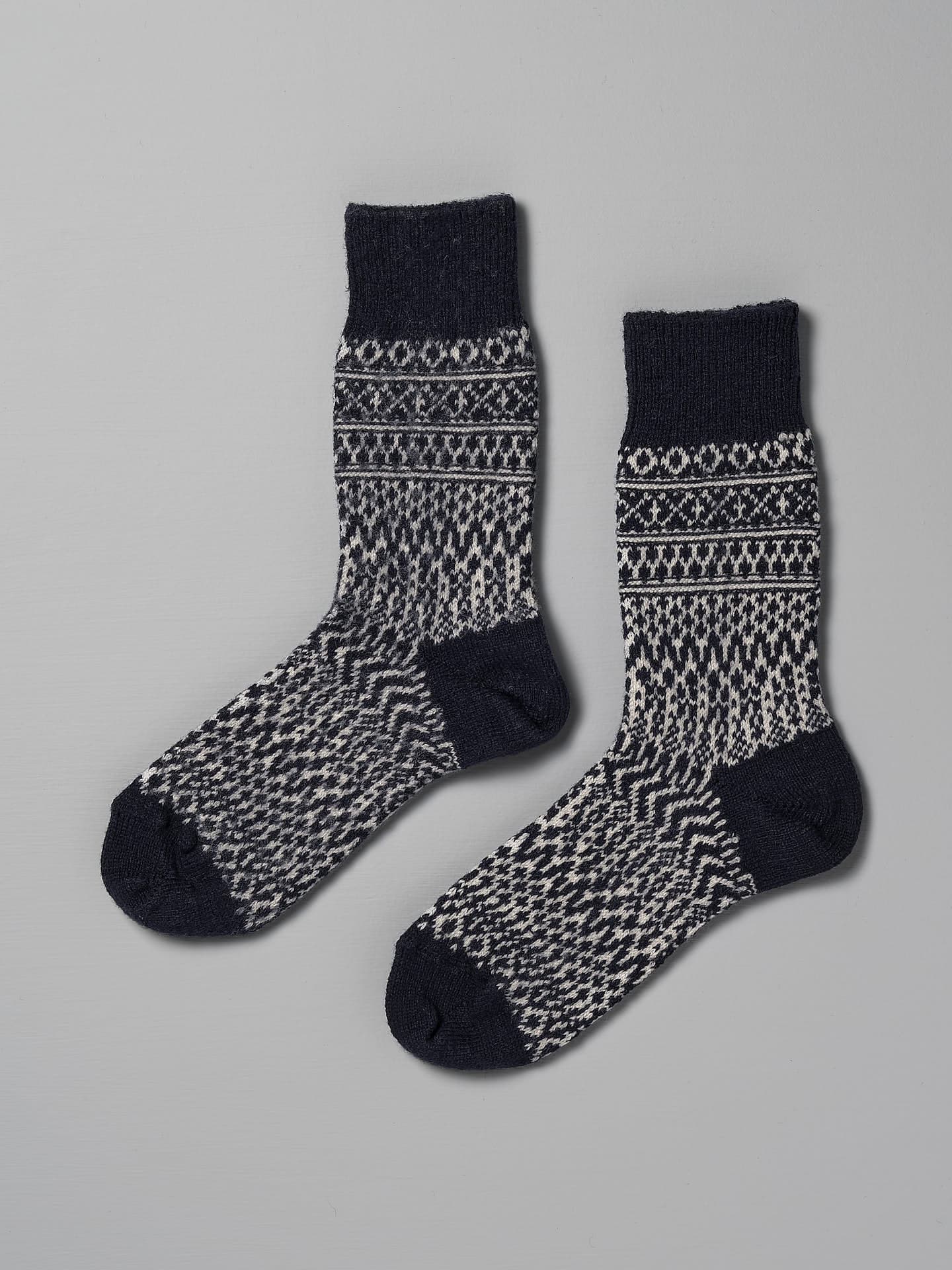 A pair of Oslo Wool Jacquard Socks – Navy by Nishiguchi Kutsushita, suitable for both women's and men's sizes, laid flat on a plain grey background.