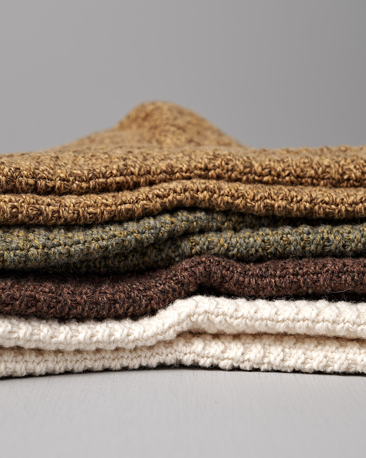 A pair of Wool Cotton Boot Socks in brown by Nishiguchi Kutsushita rests on a light surface—earthy, textured, and perfect for cozy comfort while you browse the men's size chart.