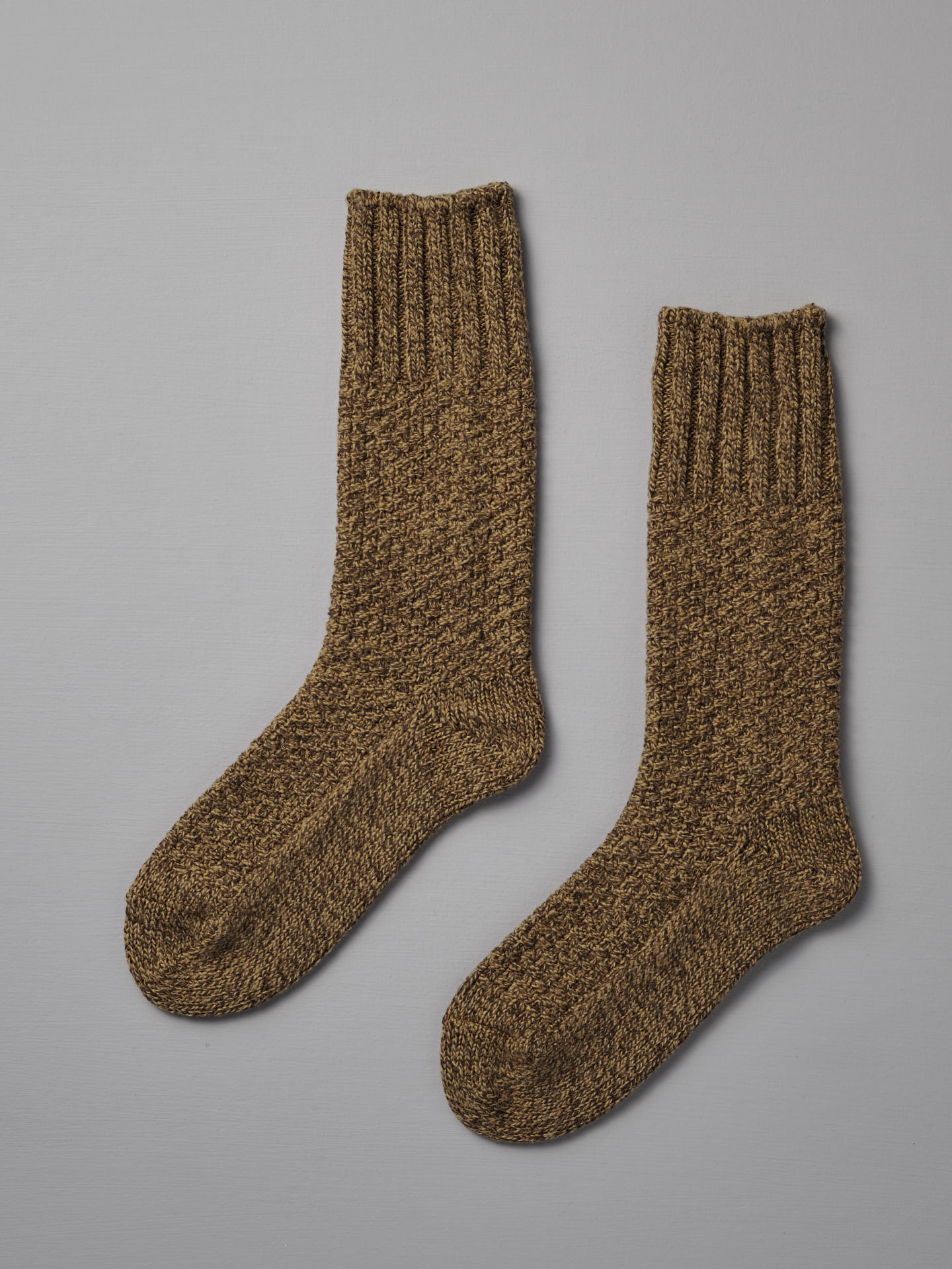 A pair of Wool Cotton Boot Socks – Mustard by Nishiguchi Kutsushita, suitable for both EUR shoe size and US men's shoe size, are laid flat on a light gray surface.