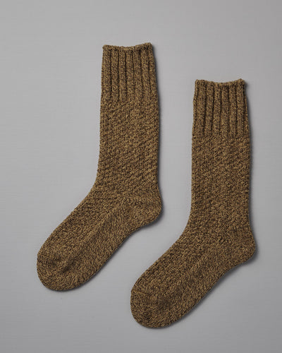 A pair of Wool Cotton Boot Socks – Mustard by Nishiguchi Kutsushita, suitable for both EUR shoe size and US men's shoe size, are laid flat on a light gray surface.