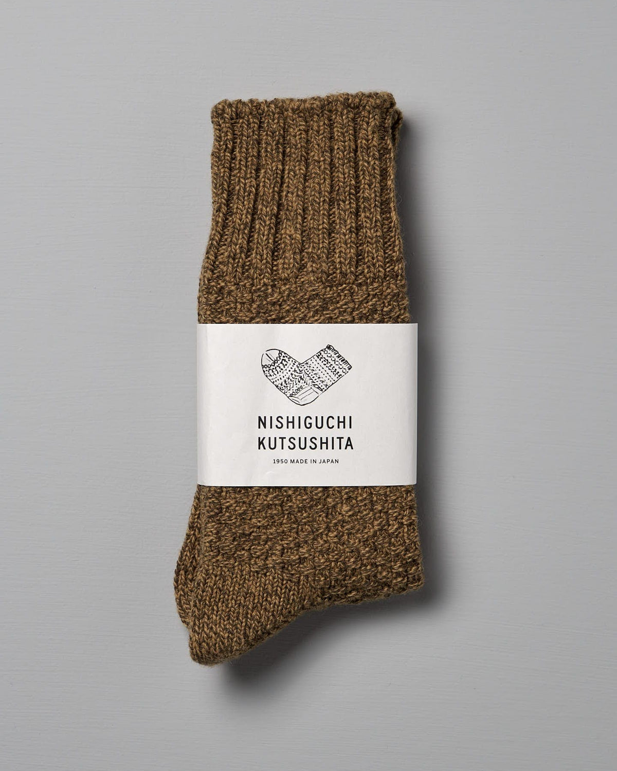 A pair of folded brown wool socks with a white label reading "Nishiguchi Kutsushita, Made in Japan," designed to fit EUR shoe sizes perfectly.
