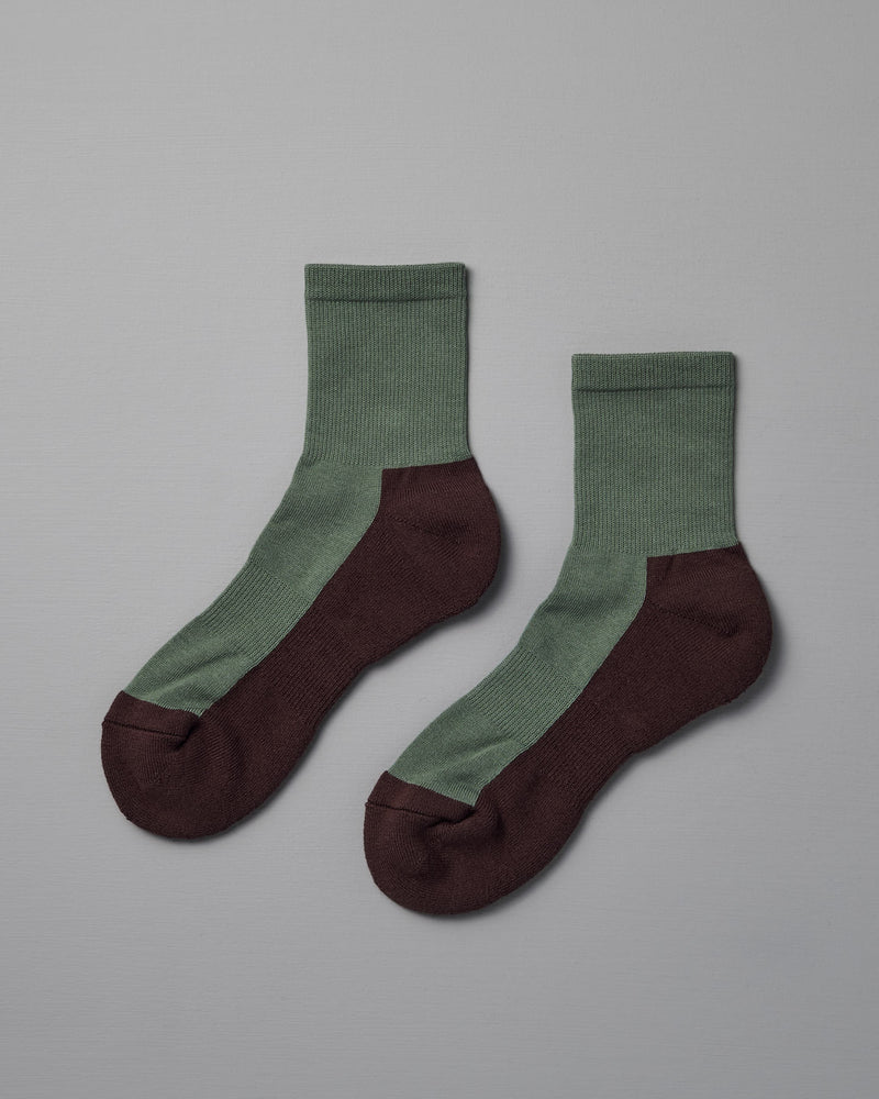 Cotton Cashmere Walk Socks – Kusamochi by Nishiguchi Kutsushita: ankle socks with green uppers and dark brown heels, toes, and soles. Available in men's sizes—see our size chart for the perfect fit. Displayed on a plain gray background.