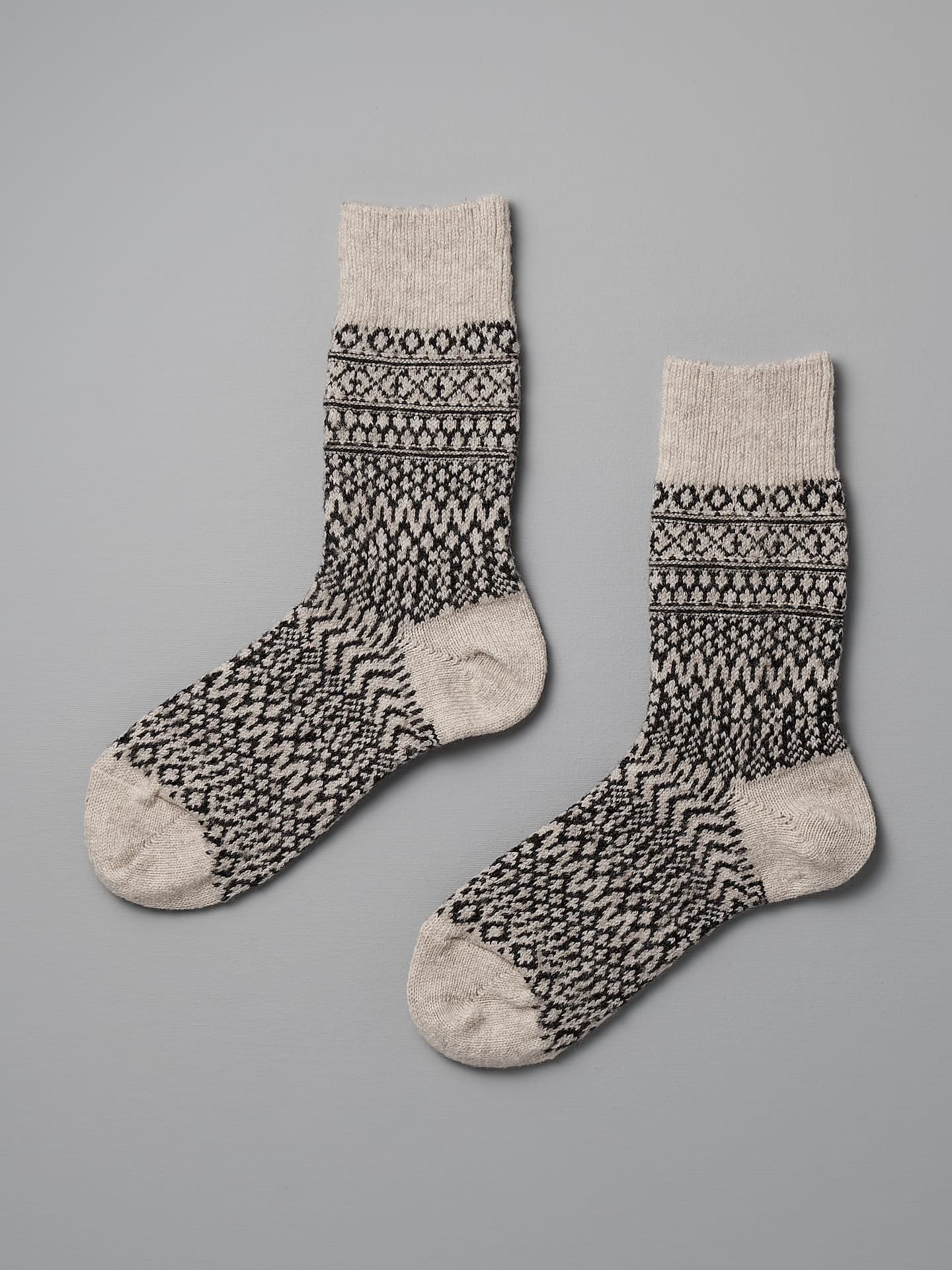 A pair of Nishiguchi Kutsushita Oslo Wool Jacquard Socks – Oatmeal, sized for EUR or US Men's & Women's, laid flat on a gray surface.