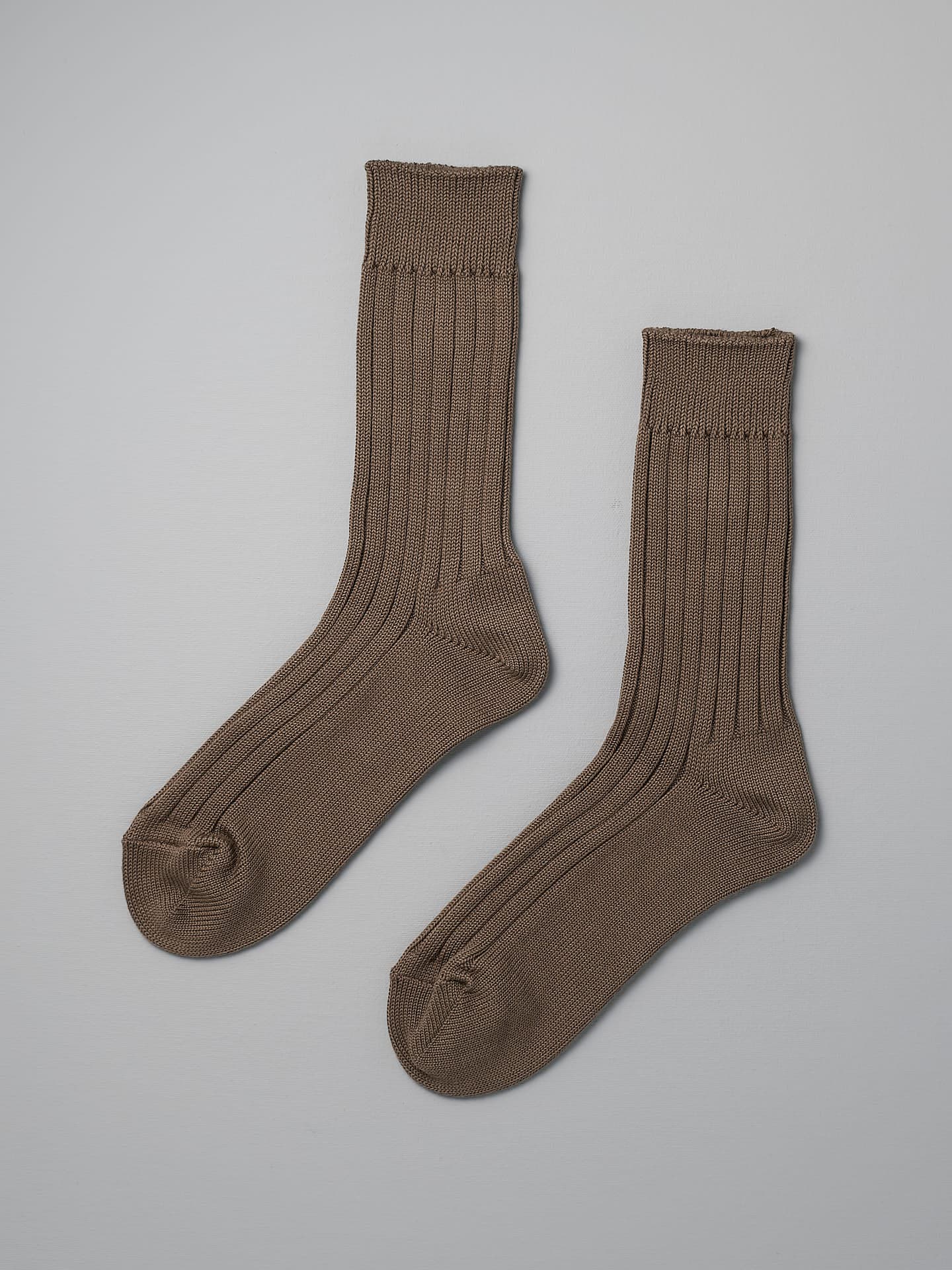 A pair of Praha Cotton Socks – Chocolate Milk by Nishiguchi Kutsushita laid flat on a light grey background, perfect to complement both men's and women's shoes. Check the size guide for the best fit across EUR and US sizes.