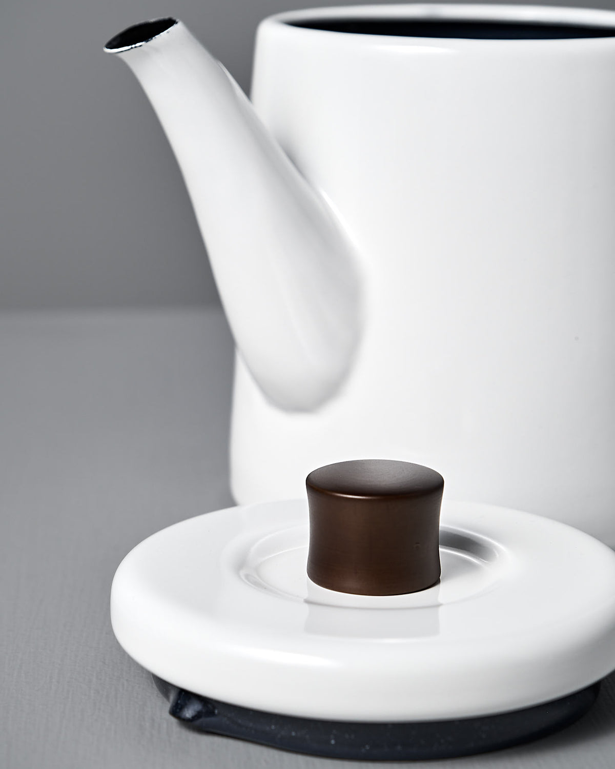 The white Potoru Stove-top Kettle/Teapot by Noda Horo, with its elegant long spout and a lid featuring a dark cylindrical knob, embodies the grace of Japanese kitchenware.