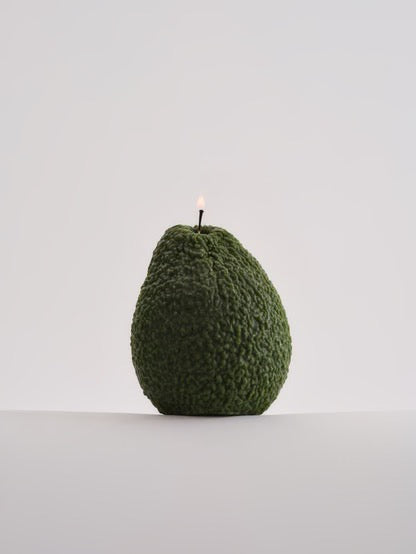 A hand-made, Nonna&#39;s Grocer Avocado Candle - Small sitting on top of a white surface.