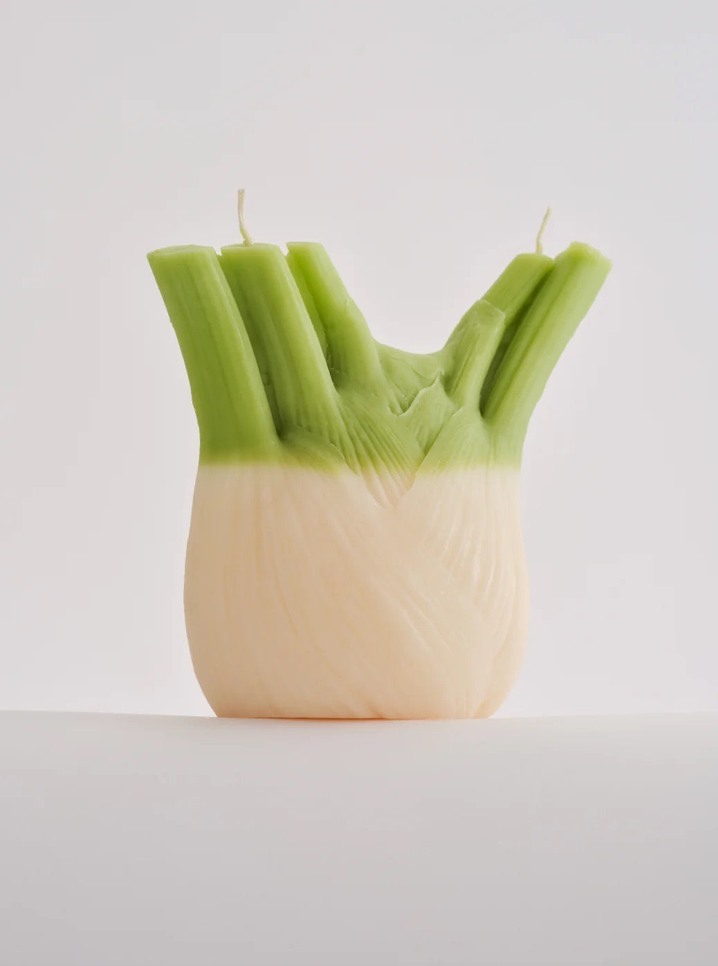 A hand-made Nonna&#39;s Grocer fennel candle made with a soy wax blend, shaped like a head of celery.