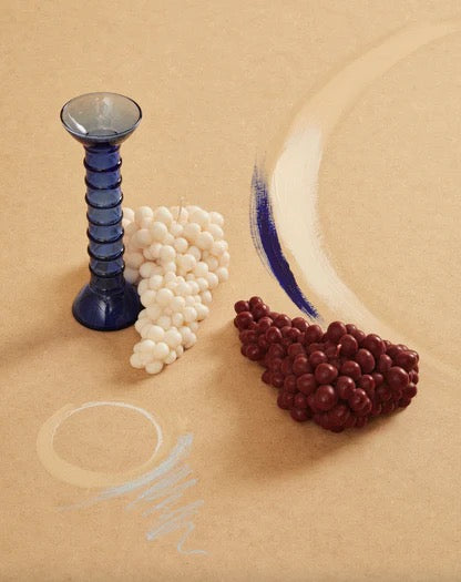 A hand-made blue and white bead vase with a Grapes Candle - Bordeaux from Nonna&#39;s Grocer on a table.