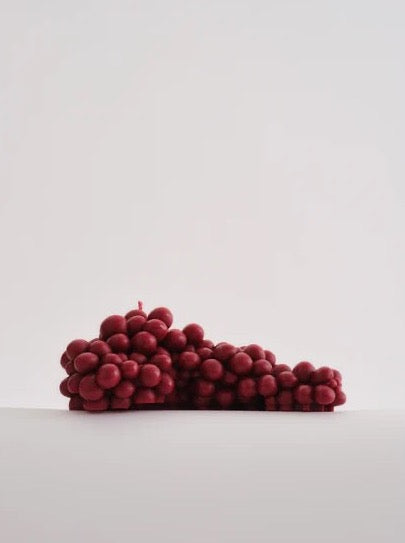 A pile of hand-made Bordeaux grapes candle from Nonna&#39;s Grocer on a white background.