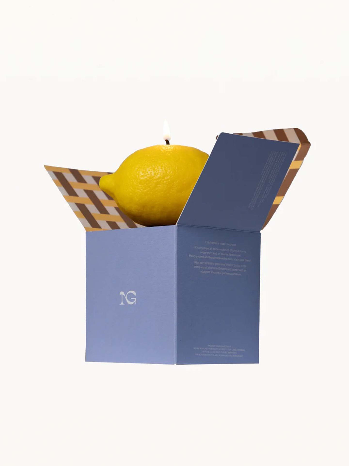 Inside an open blue and brown checkered box, crafted from a natural soy wax blend, sits the Scented Lemon Candle by Nonna&#39;s Grocer, shaped like a lemon peel.