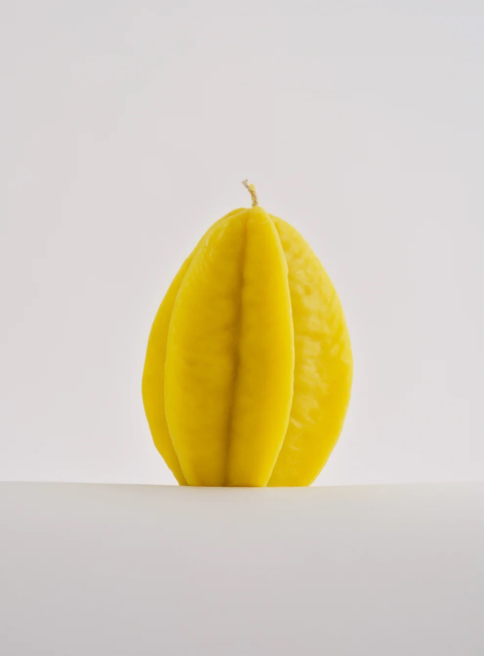 A Nonna&#39;s Grocer Starfruit Candle – Large sitting on a white surface.