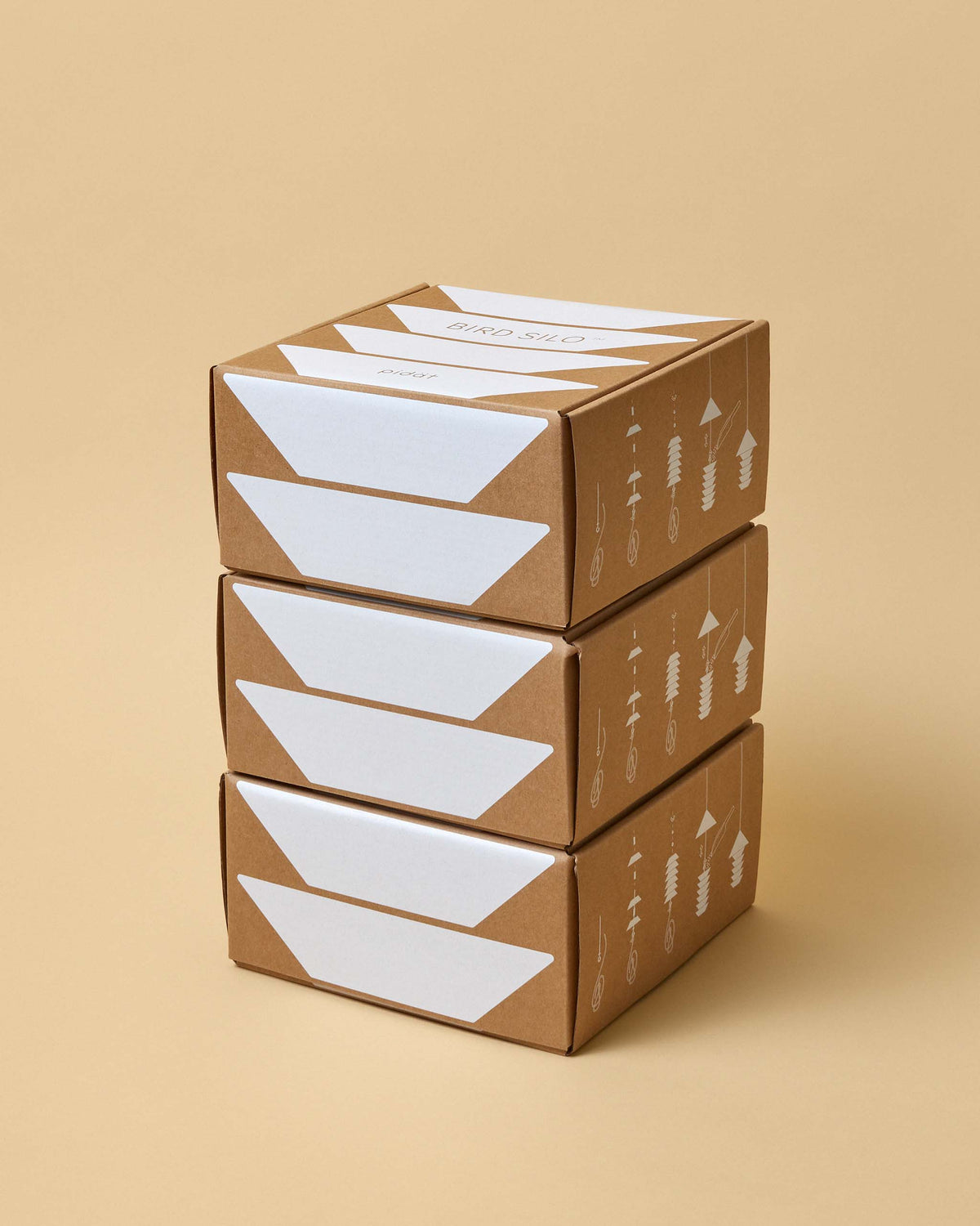 Three stacked brown cardboard boxes with white geometric designs, placed on a neutral beige background.