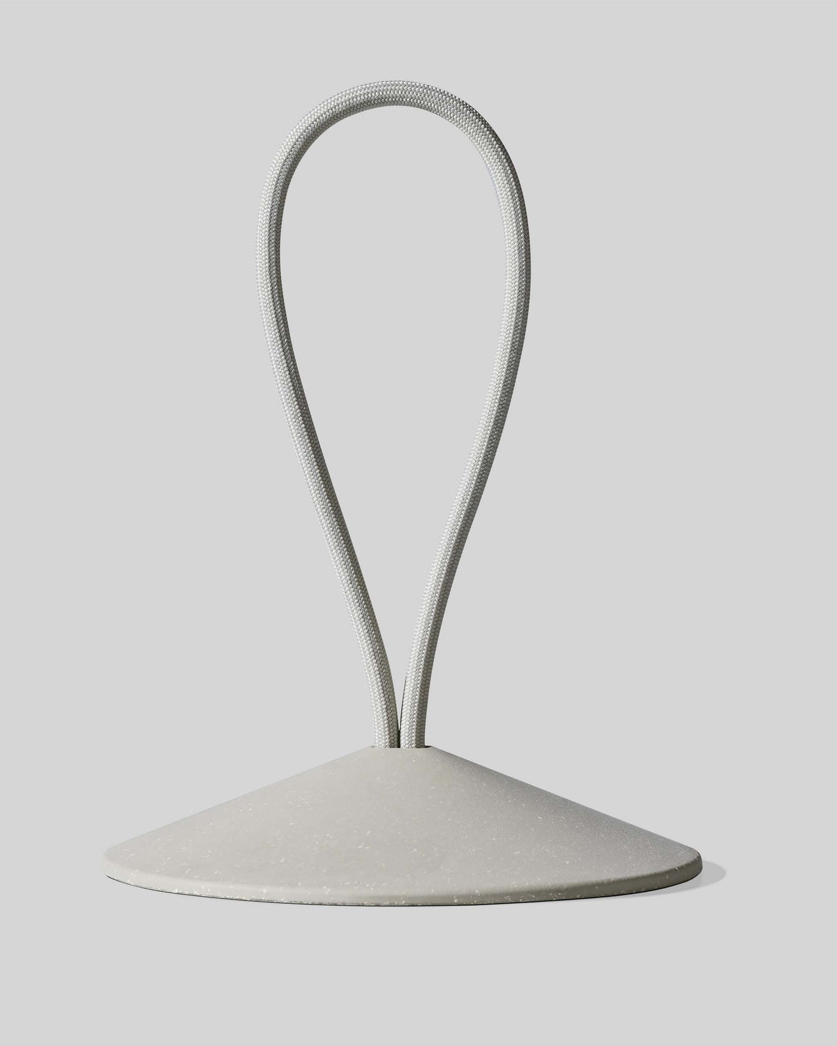 A conical base with a looped, flexible cord extending upward from its top, set against a plain light gray background.
