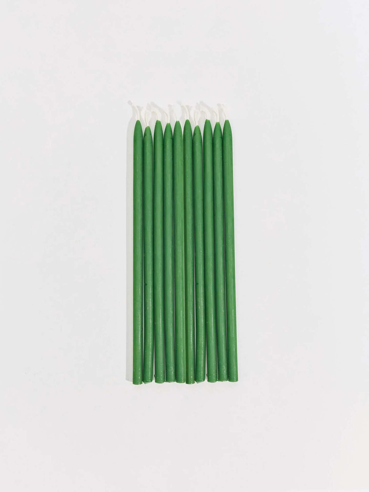 Eight Tall Celebration Candles – Mix & Match, handmade in green, are arranged in a neat row on a plain white background.