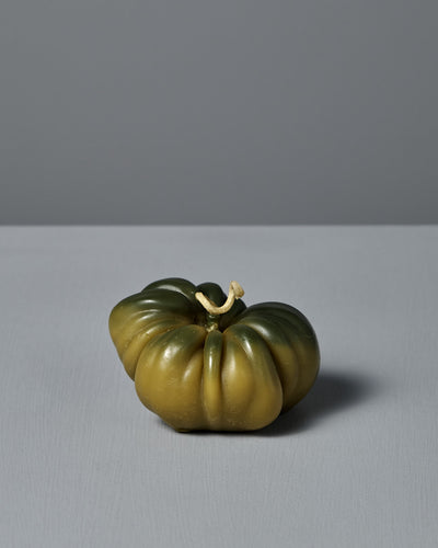 The Green Heirloom Tomato Candle – Large, handmade from pure New Zealand beeswax, with a short stem, sits on a light gray surface against a simple gray background.