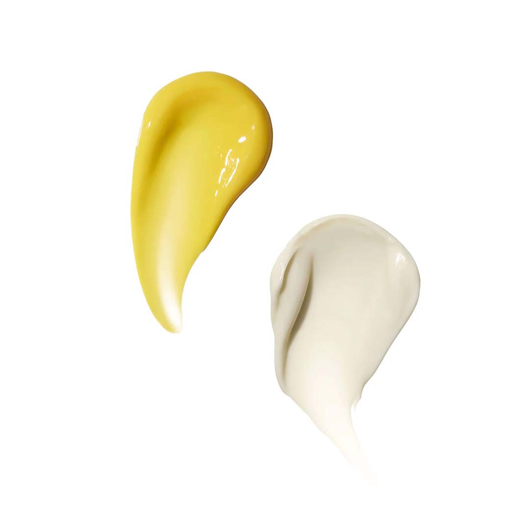 Two cream smears on a white background: one yellow and smooth, the other white and slightly textured, reminiscent of RAAIE&#39;s Lunar Repair Duo, perfect for your skincare needs.