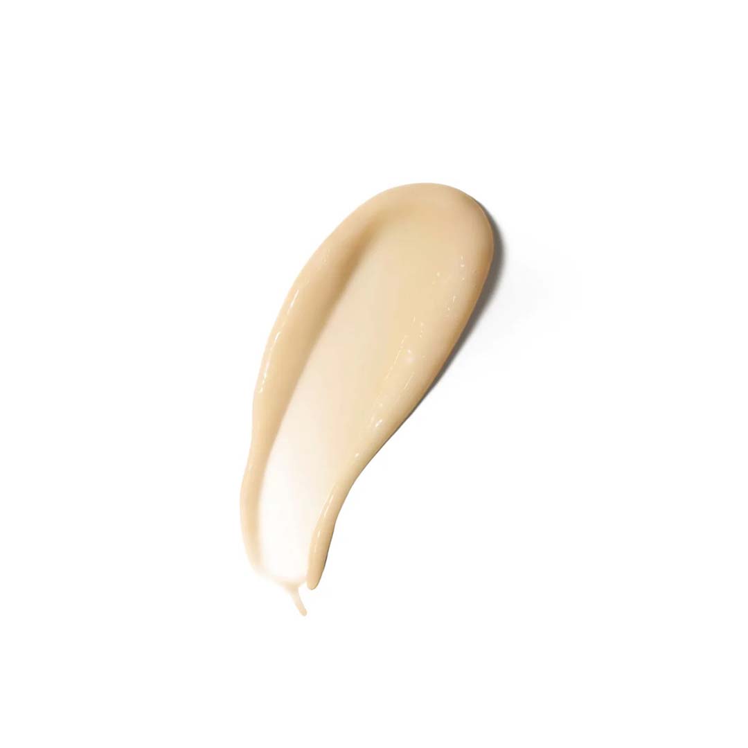 A close-up of a beige-colored smear of creamy substance, rich with the benefits of RAAIE&#39;s Morning Dew Vitamin C Serum, on a white background.