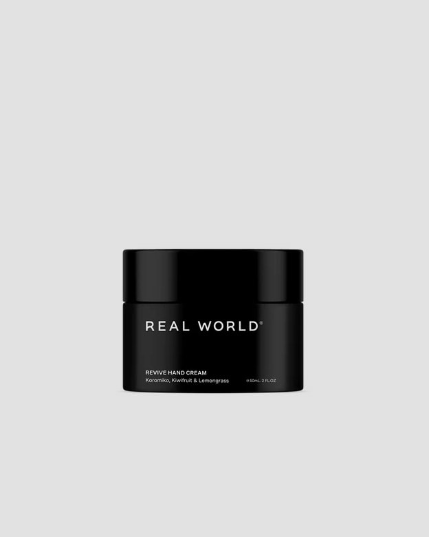 A black jar of Revive Hand Cream – Koromiko, Kiwifruit & Lemongrass by Real World, infused with kiwifruit extract and Koromiko extract.
