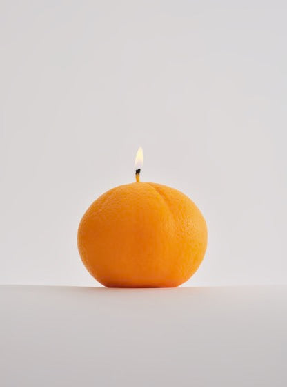A Nonna's Grocer Mandarin Candle - Large, crafted with a soy wax blend, sitting on a white surface.