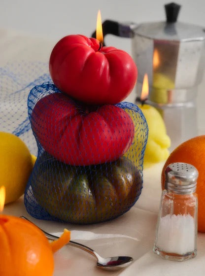 A hand-made display of Tomato Candles - Medium from Nonna&#39;s Grocer on a table, designed with lifelike qualities.