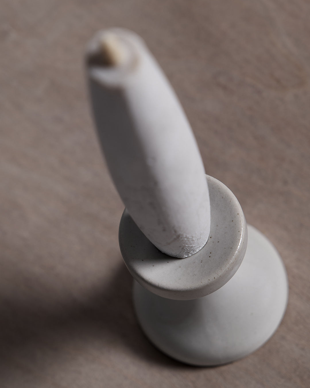 A small Takazawa Stoneware Candle Holder on a wooden table.