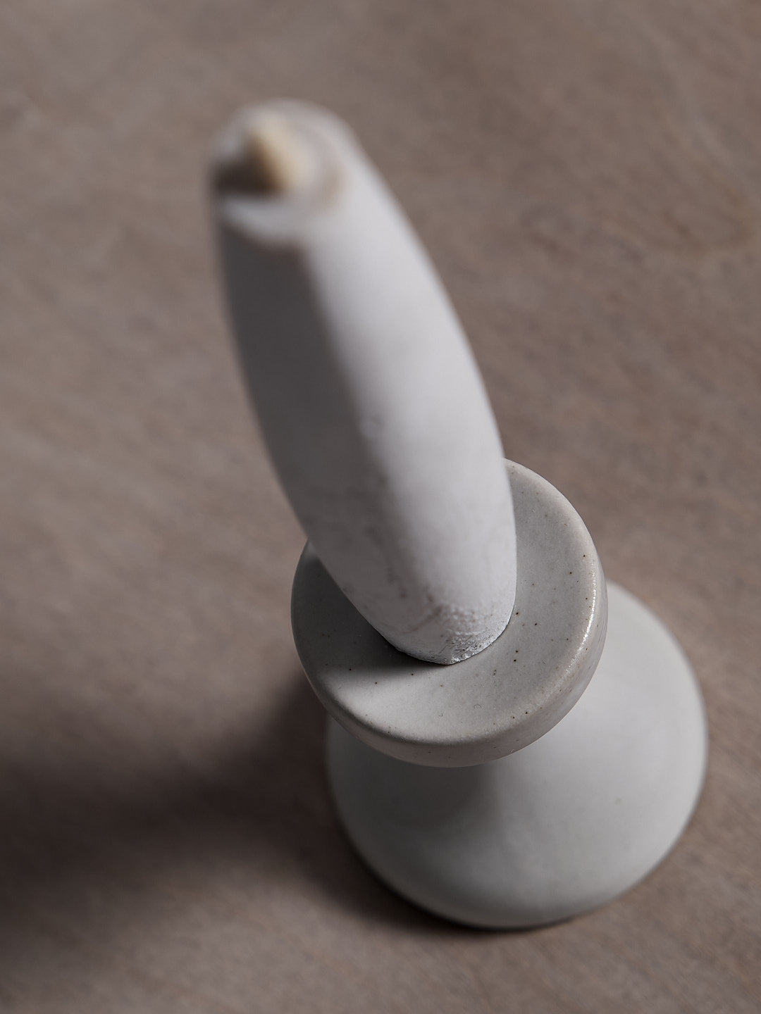 A small Takazawa Stoneware Candle Holder on a wooden table.