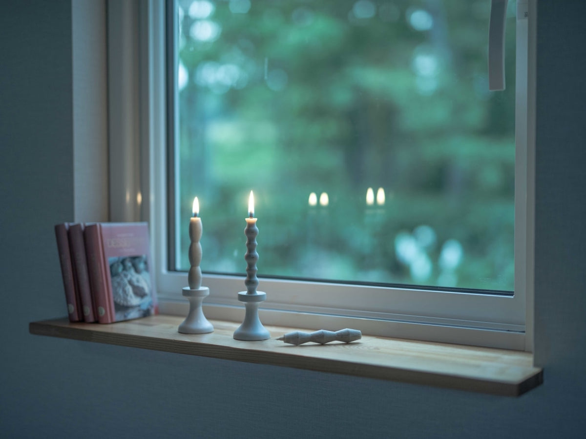 Two FLUID – Takazawa stoneware candle holders and books on a window sill.