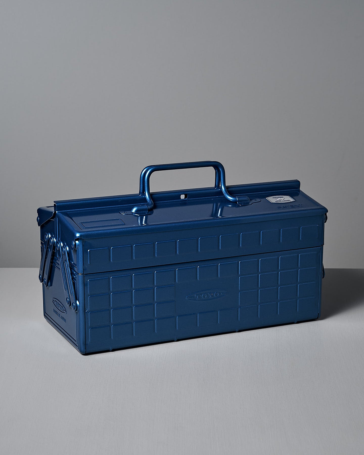 The TOYO STEEL Cantilever Toolbox ST-350 – Blue, featuring powder-coated steel and a checkered pattern, is placed on a white surface against a gray background.