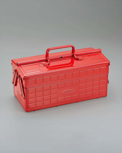 Red metal cantilever toolbox with a handle and embossed grid pattern.