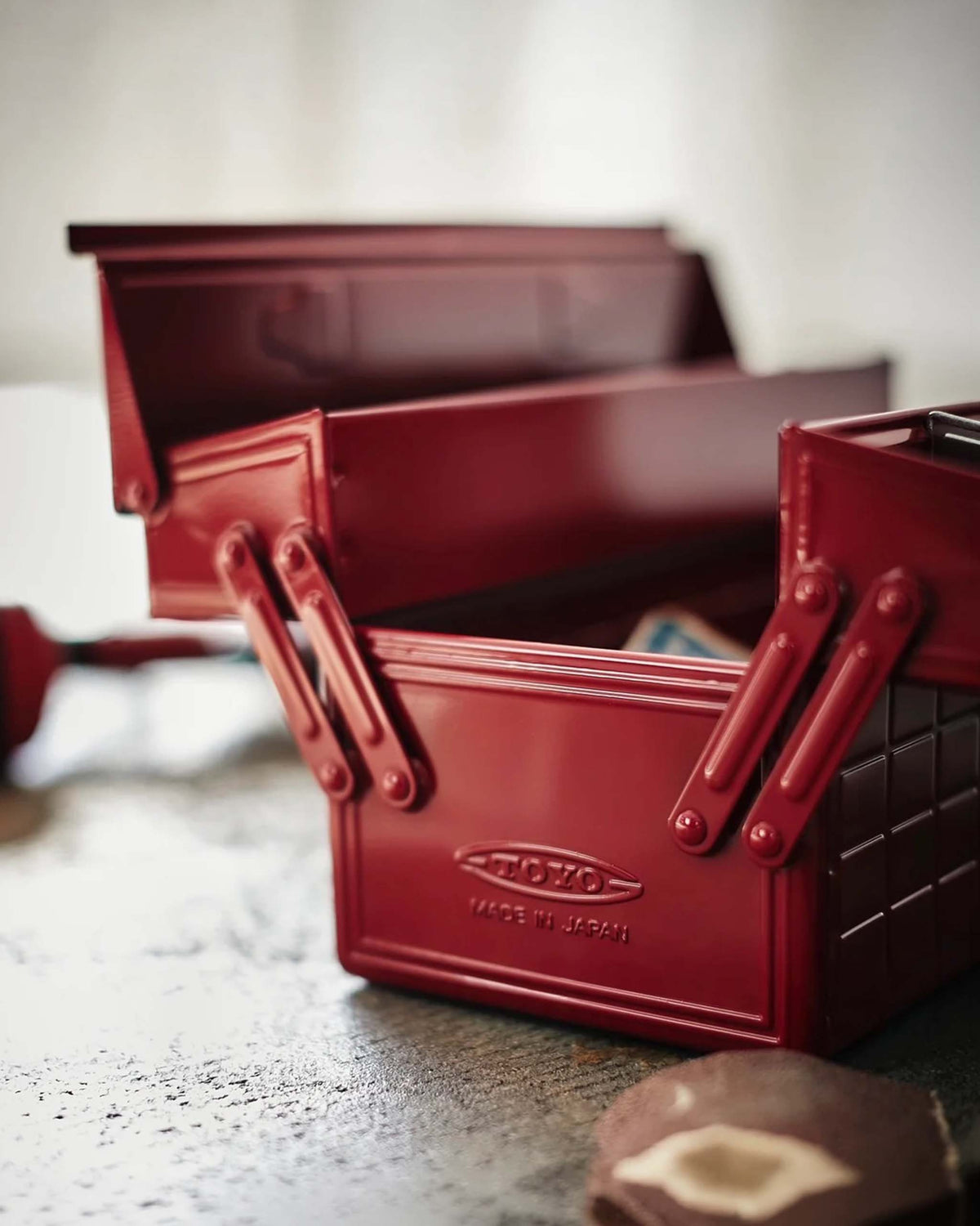Red metal cantilever toolbox with “TOYO” and “MADE IN JAPAN” embossed on the front.