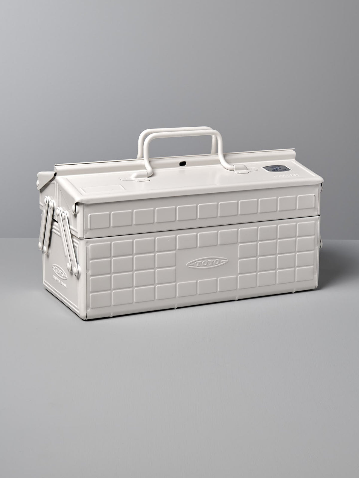 A white, rectangular powder-coated steel toolbox with a handle on top and a latch on the front, placed against a gray background. The Cantilever Toolbox ST-350 – White by TOYO STEEL earned the prestigious Good Design Award 2009.