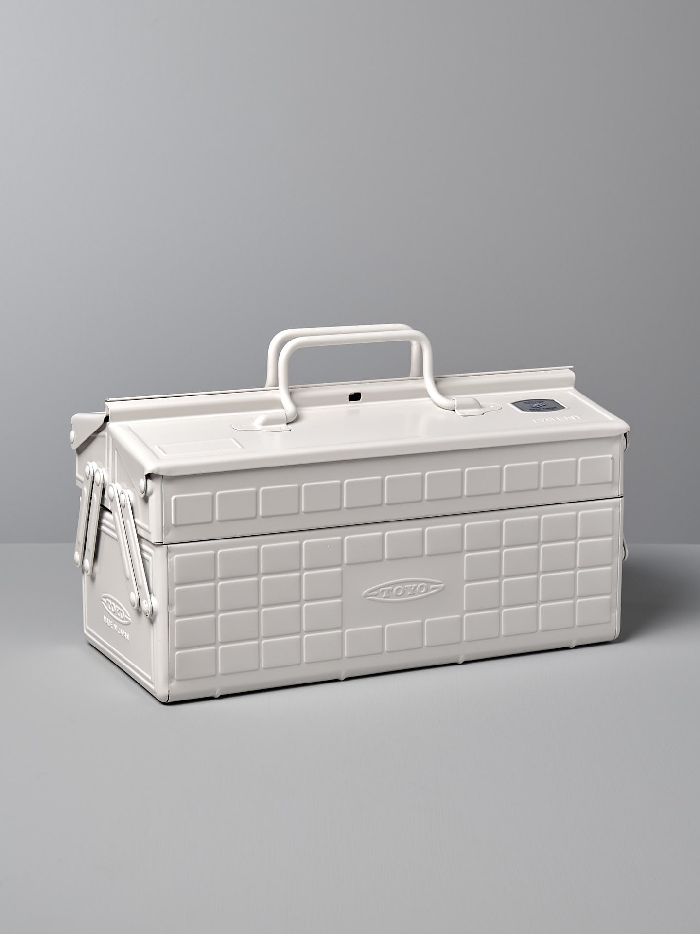 A white, rectangular powder-coated steel toolbox with a handle on top and a latch on the front, placed against a gray background. The Cantilever Toolbox ST-350 – White by TOYO STEEL earned the prestigious Good Design Award 2009.