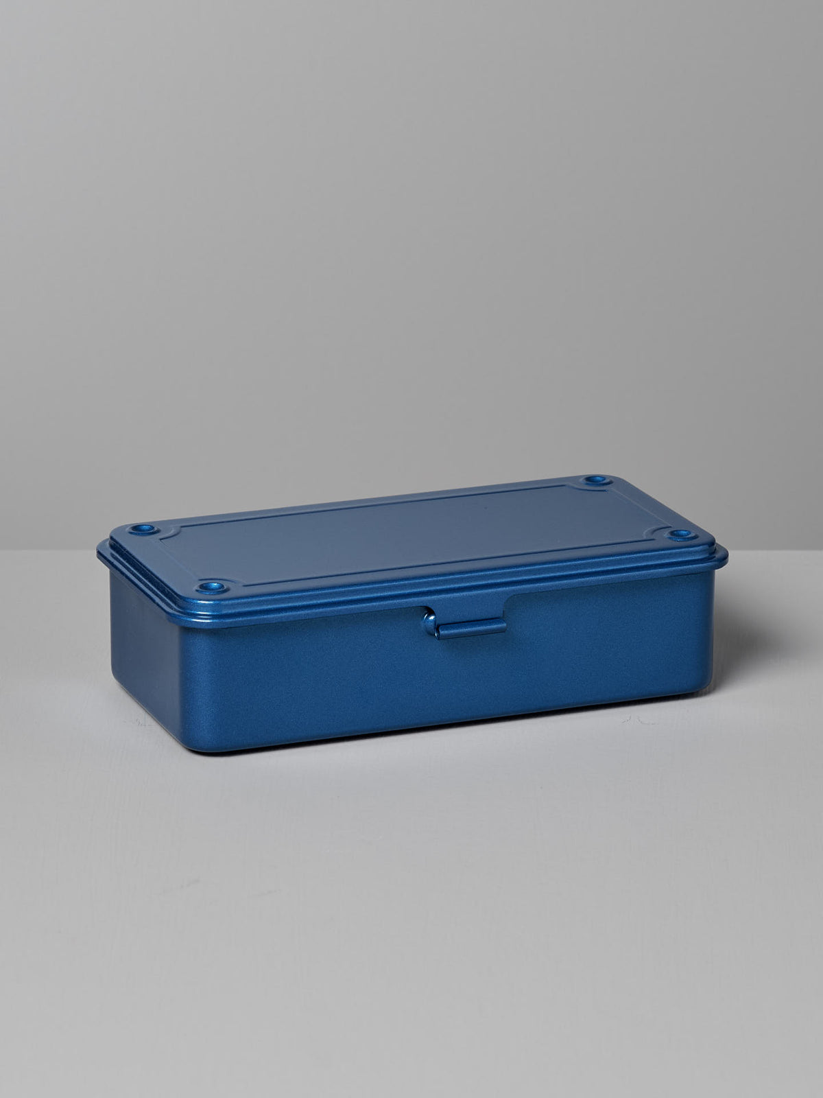 A Mini Steel Toolbox T-190 – Blue by TOYO STEEL with a hinged lid sits on a gray surface against a gray background, offering a versatile storage solution.