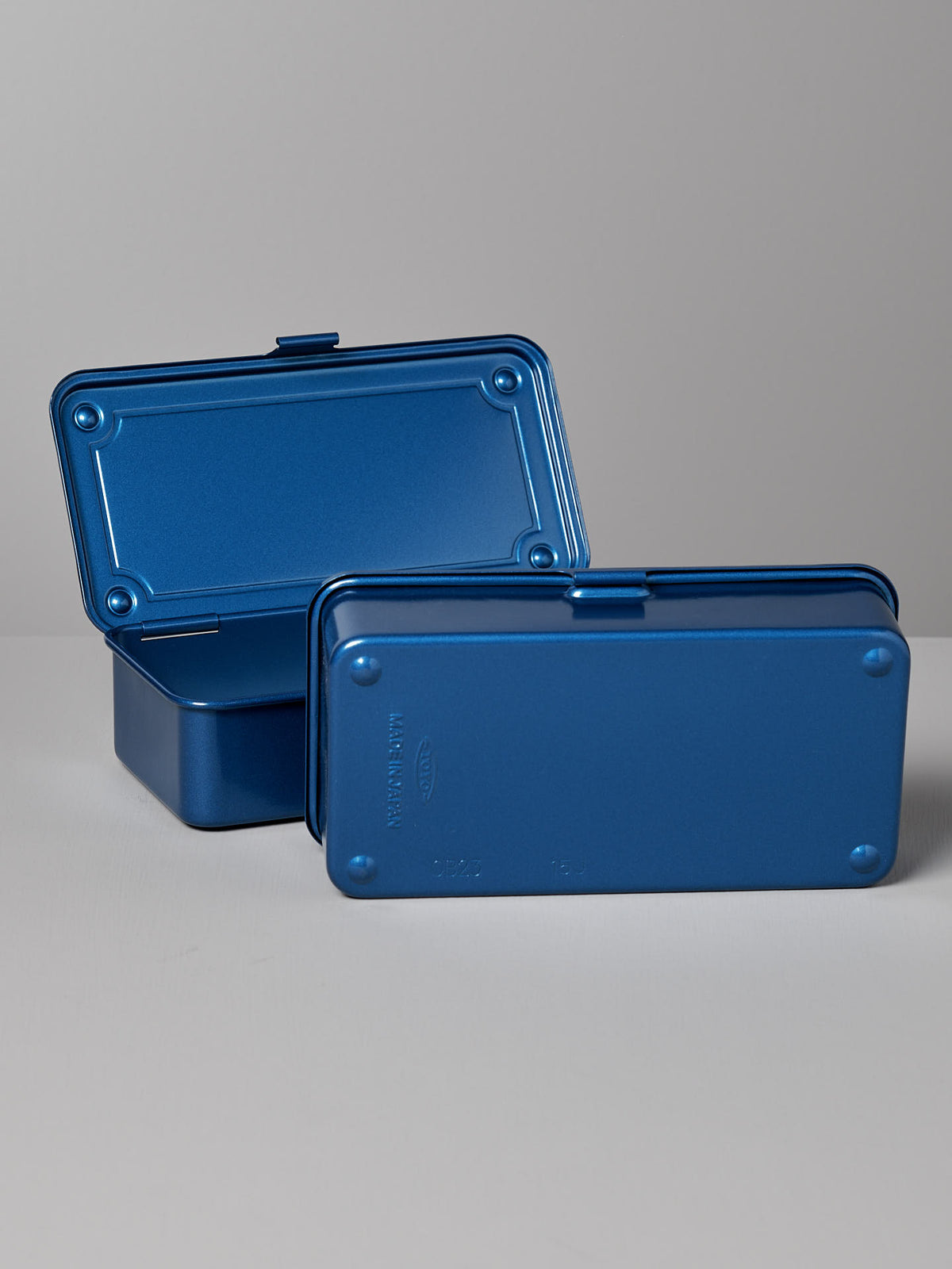 Two rectangular blue TOYO STEEL Mini Steel Toolbox T-190 – Blue with hinged lids are placed on a light surface. One versatile storage solution is open, and the other is closed.