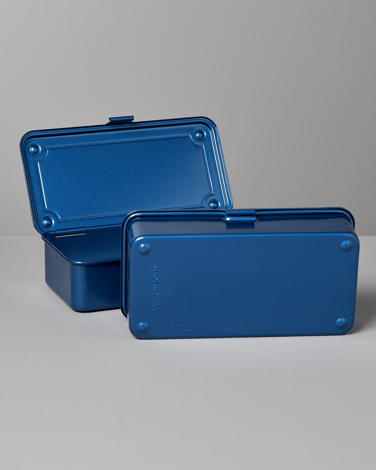 Two rectangular blue TOYO STEEL Mini Steel Toolbox T-190 – Blue with hinged lids are placed on a light surface. One versatile storage solution is open, and the other is closed.