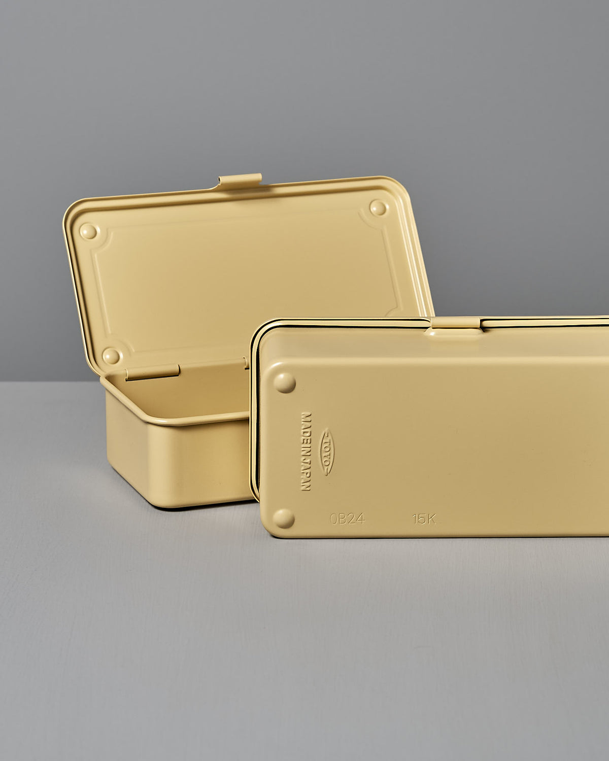 Two open rectangular TOYO STEEL Mini Steel Toolbox T-190 in Italian Yellow sit on a gray surface; one is upright, and the other lies flat, offering a versatile design to enhance any space.