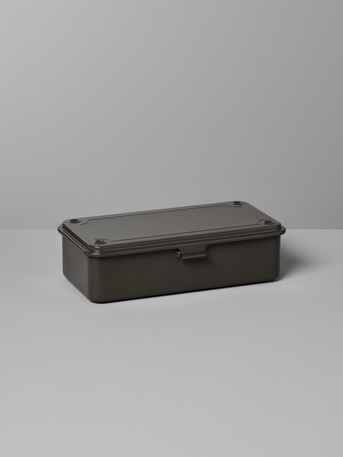 A rectangular, moss green steel storage box with a hinged lid and latch, placed on a light gray surface against a light gray background. Made in Japan, this versatile design is perfect for organizing your essentials. The Mini Steel Toolbox T-190 – Moss Green by TOYO STEEL is an excellent choice for keeping your items neatly stored.