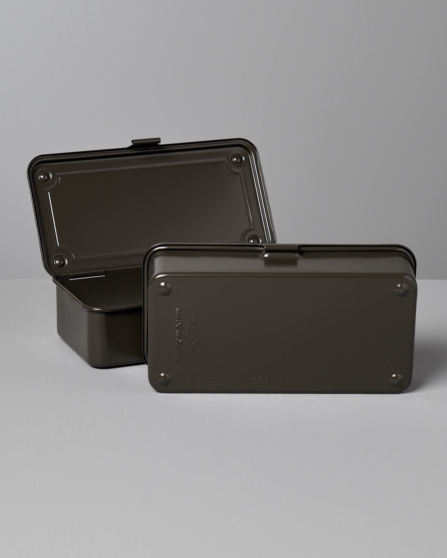 A rectangular, moss green steel storage box with a hinged lid and latch, placed on a light gray surface against a light gray background. Made in Japan, this versatile design is perfect for organizing your essentials. The Mini Steel Toolbox T-190 – Moss Green by TOYO STEEL is an excellent choice for keeping your items neatly stored.
