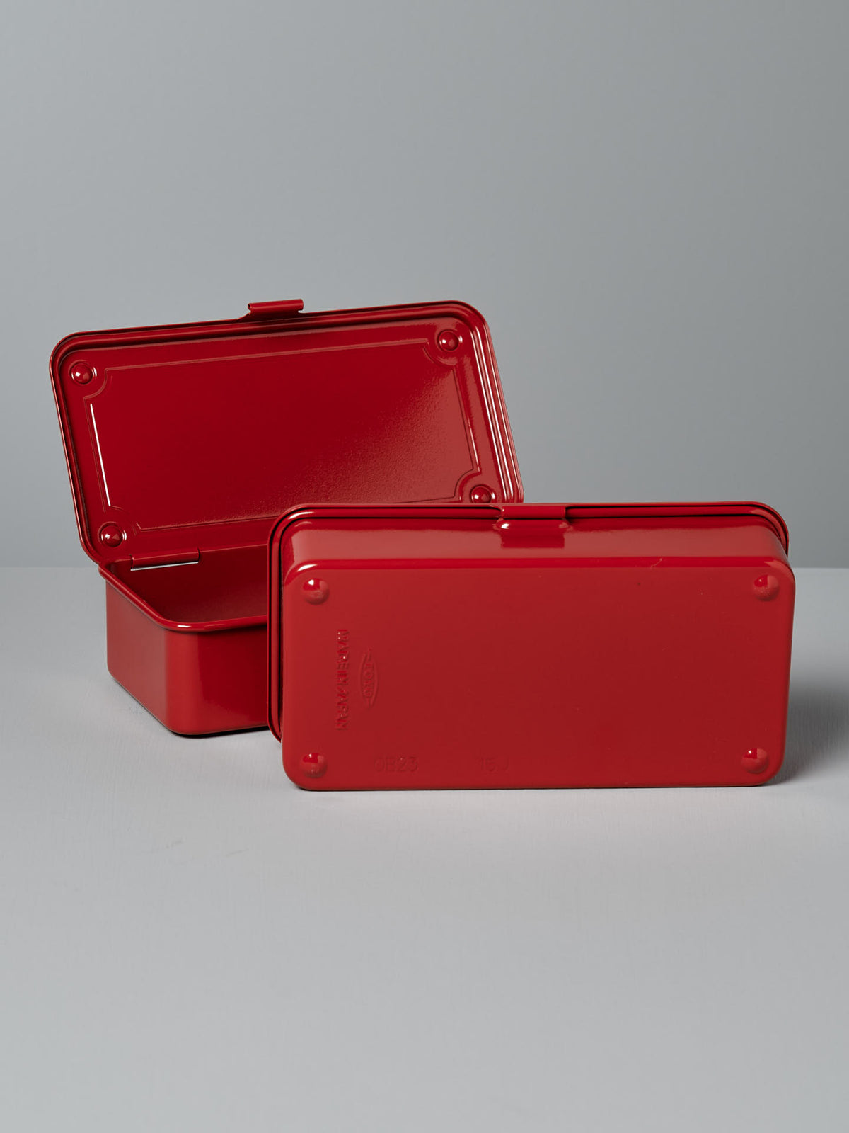 Two TOYO STEEL Mini Steel Toolbox T-190 – Red containers with hinged lids, one open to reveal the seamless design interior, and the other closed, positioned side by side on a flat surface.