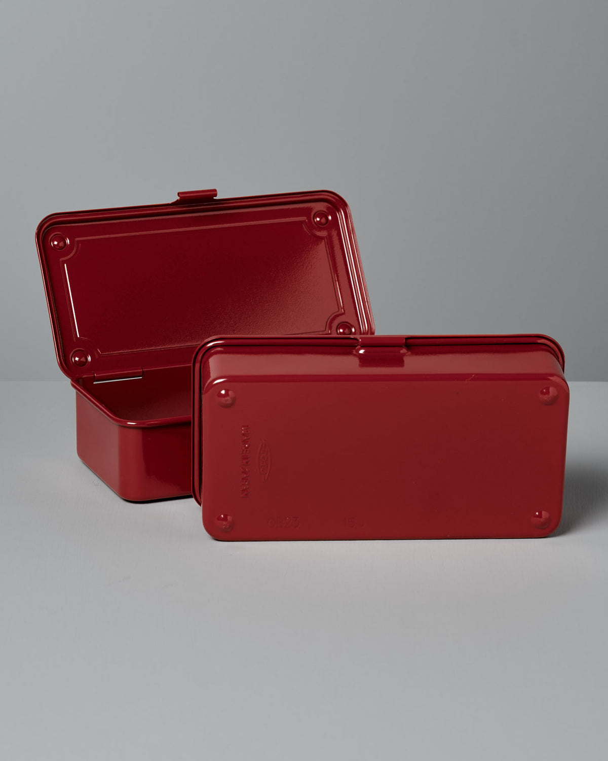 Two Mini Steel Toolboxes T-190 in red, crafted by TOYO STEEL from powder-coated steel, are placed on a neutral surface against a gray background. One toolbox is open while the other remains closed, showcasing their stackable design.