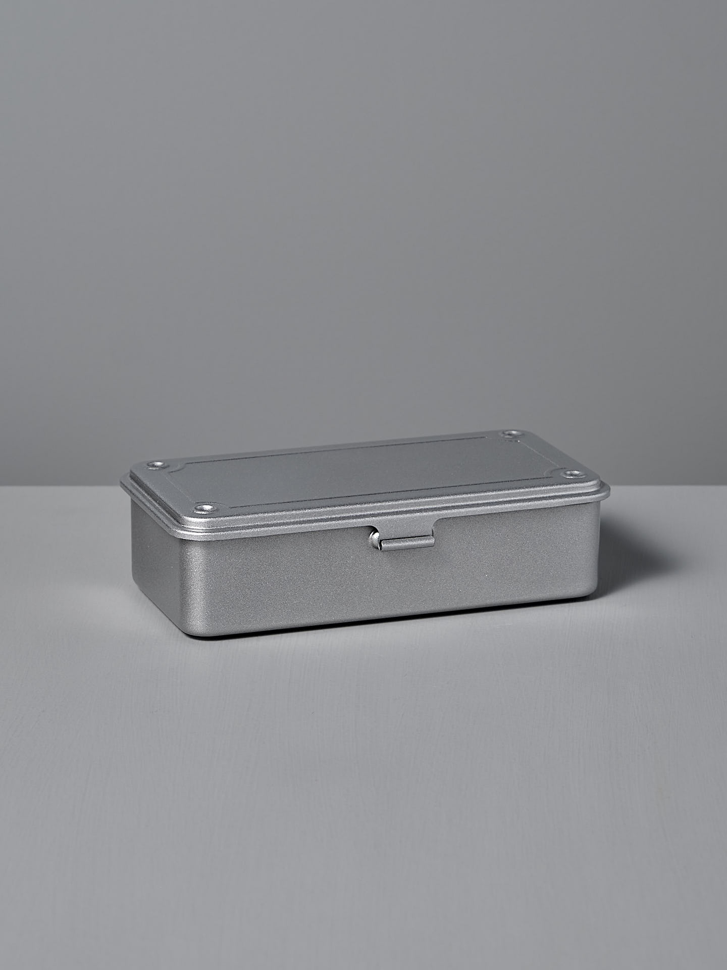 The TOYO STEEL Mini Steel Toolbox T-190 – Silver is a closed, rectangular metallic box with a latch that sits on a flat surface against a plain background.
