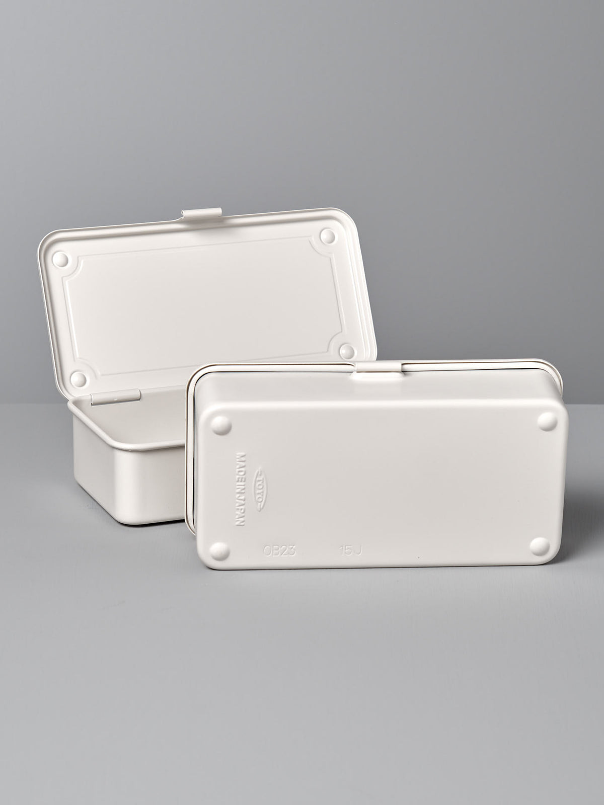 Two white, rectangular plastic containers with hinged lids are shown, one of which is open while the other is closed. They feature a versatile design and are set against a neutral background, highlighting their simple, plain design. These containers are actually the Mini Steel Toolbox T-190 – White by TOYO STEEL.