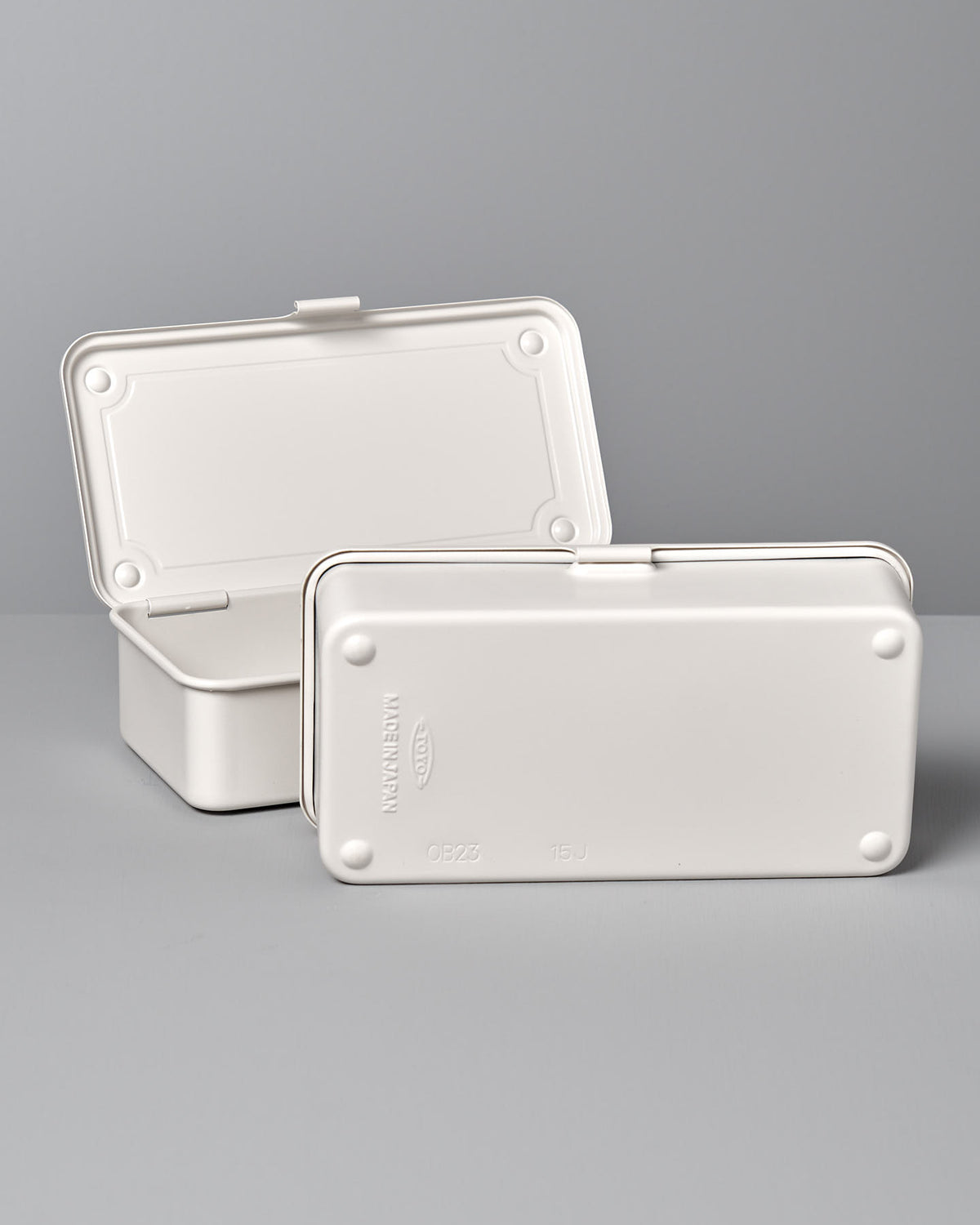 Two white, rectangular plastic containers with hinged lids are shown, one of which is open while the other is closed. They feature a versatile design and are set against a neutral background, highlighting their simple, plain design. These containers are actually the Mini Steel Toolbox T-190 – White by TOYO STEEL.