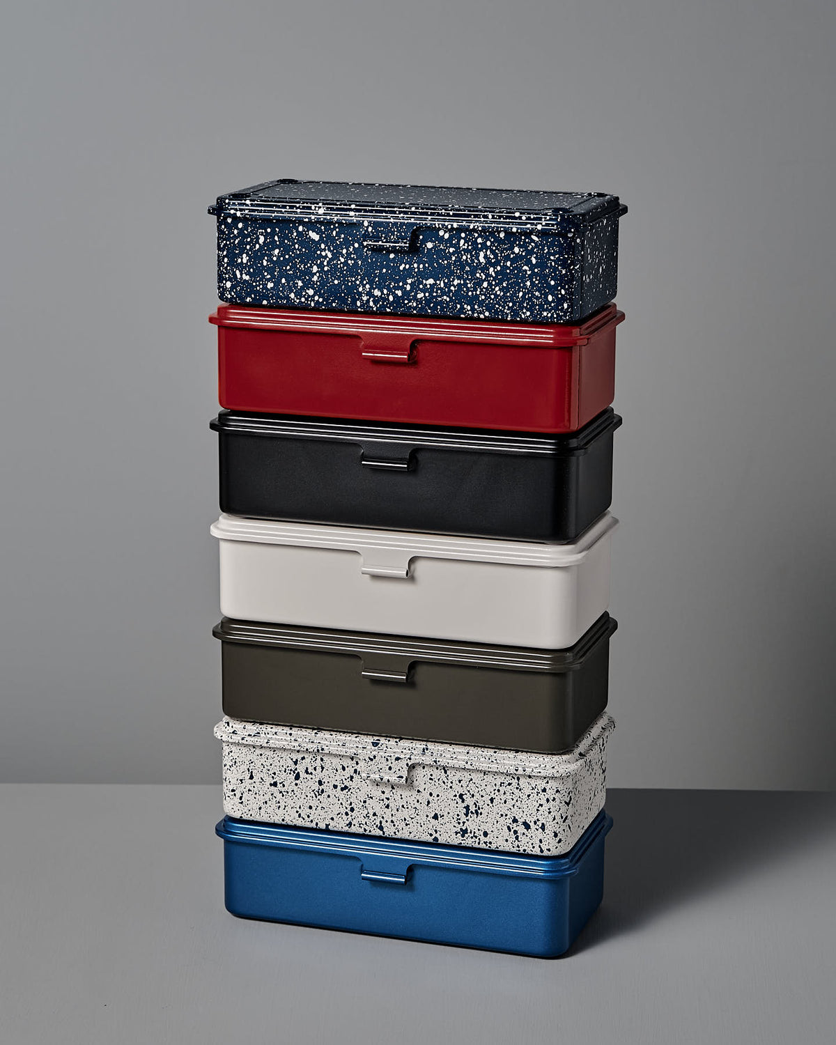 A stackable set of six rectangular storage boxes crafted from powder-coated steel by TOYO STEEL, showcasing various colors and patterns, including a design like the Mini Steel Toolbox T-190 in Japanese Indigo.