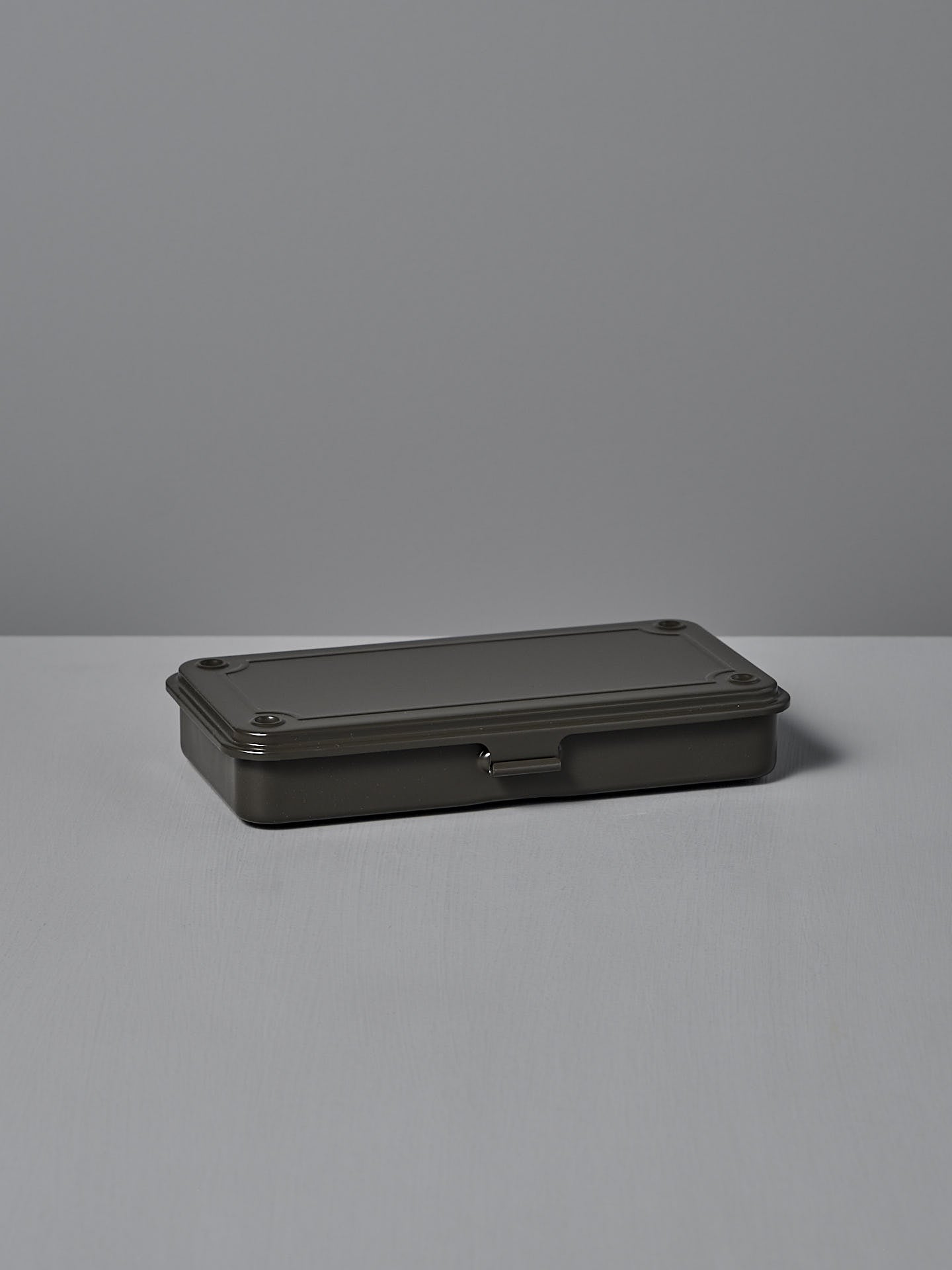Under soft light on a gray surface sits the TOYO STEEL Mini Steel Toolbox T-192 in Moss Green, crafted from powder-coated steel for versatile storage.